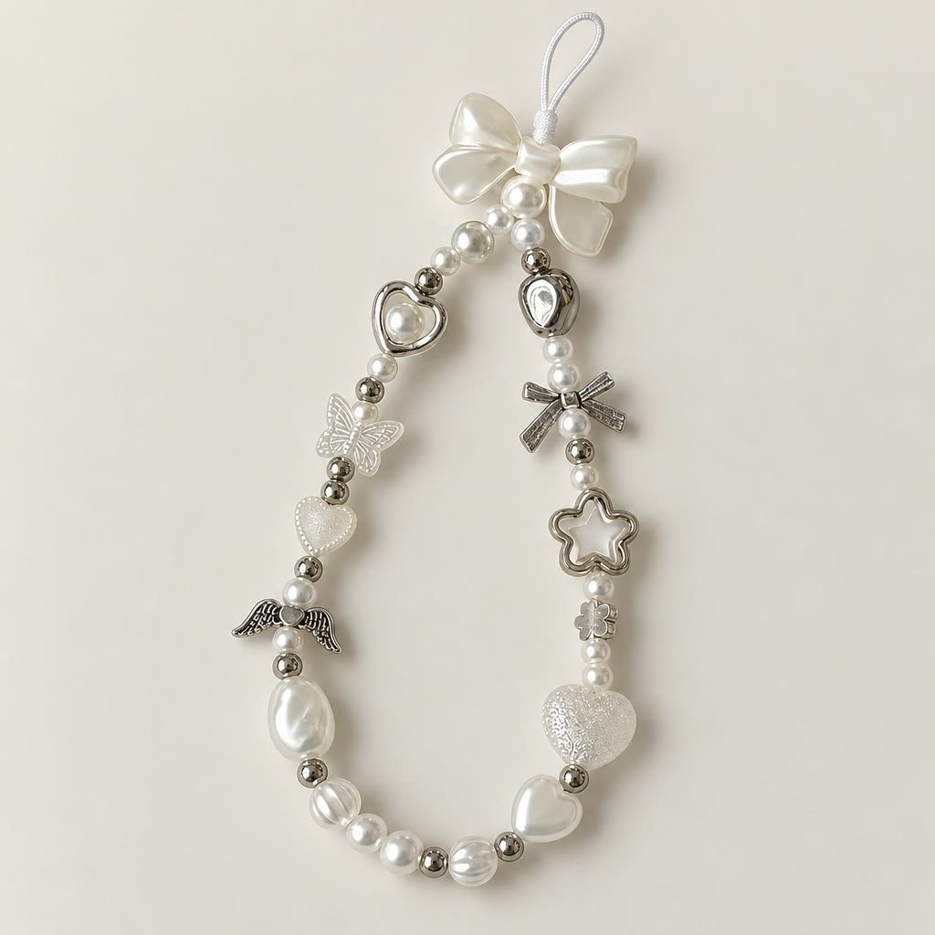 Pearl wrist strap laid flat: pearls, silver beads, a bow, hearts and a star charm